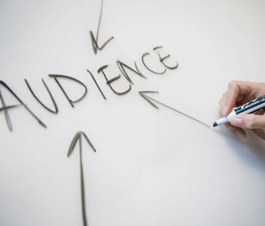 Whiteboard with arrows pointing to the word 'Audience' with a hand holding a white board marker on the right hand side