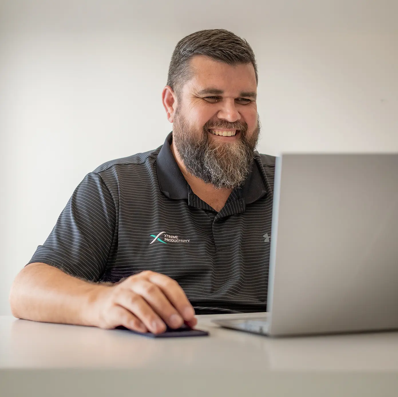 XP Staff member working in the office with a laptop